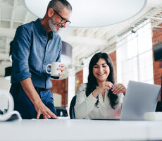 two business people working at a desk looking at a computer